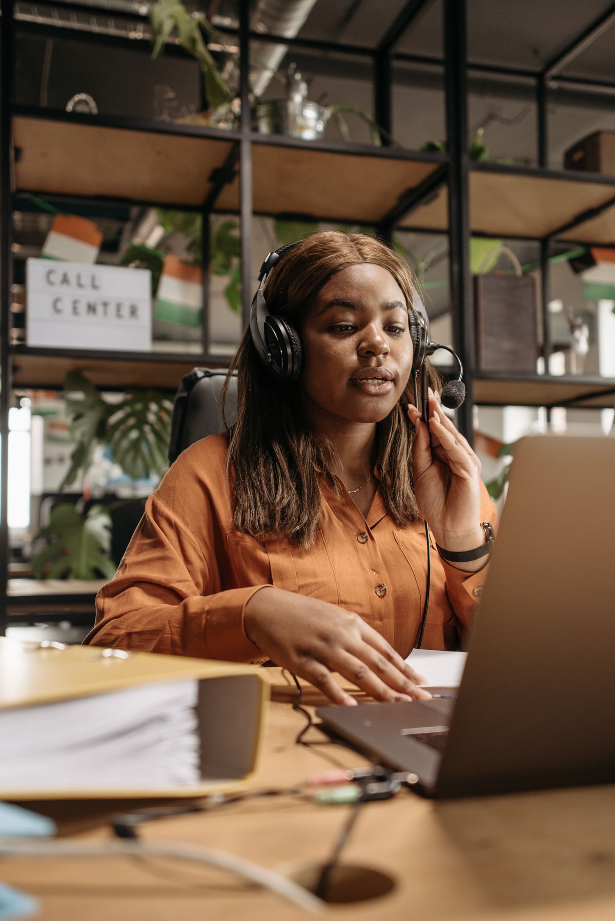 A woman wearing a headset answering calls on the 24/7 helpline